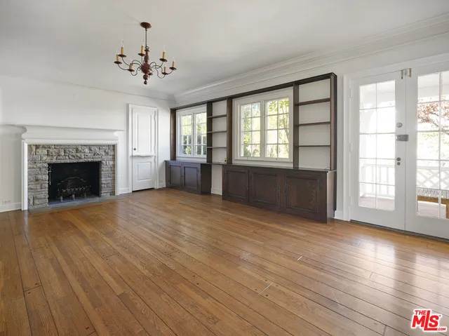 wooden floor fireplace and windows in an empty room