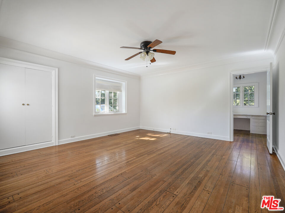 13161 Addison Street Sherman Oaks, CA 91423 - Photo 15 of 34 an empty room with wooden floor chandelier fan and windows