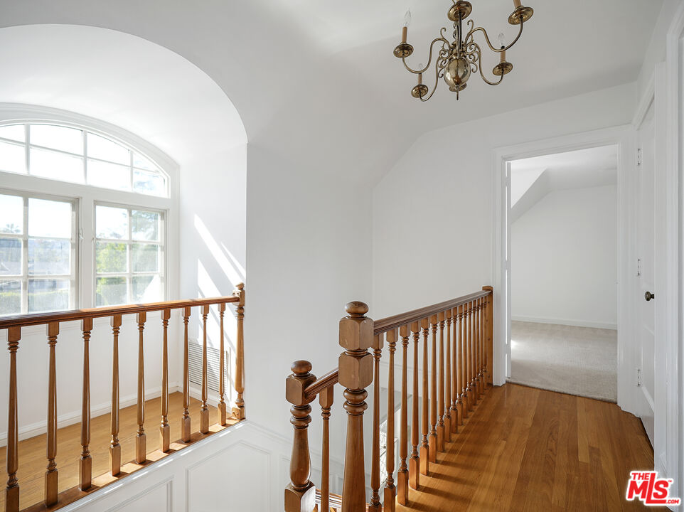 13161 Addison Street Sherman Oaks, CA 91423 - Photo 19 of 34 a view of a hallway with wooden floor and staircase