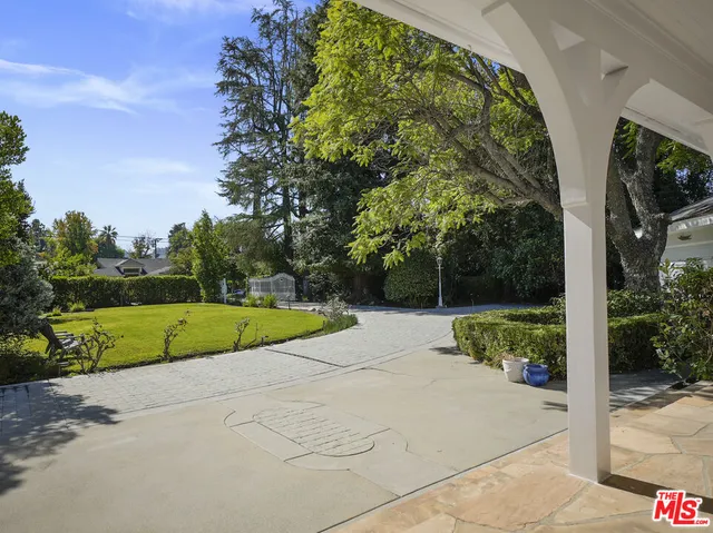 a view of a garden with large trees