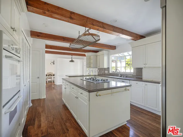a kitchen with a stove and a wooden floors