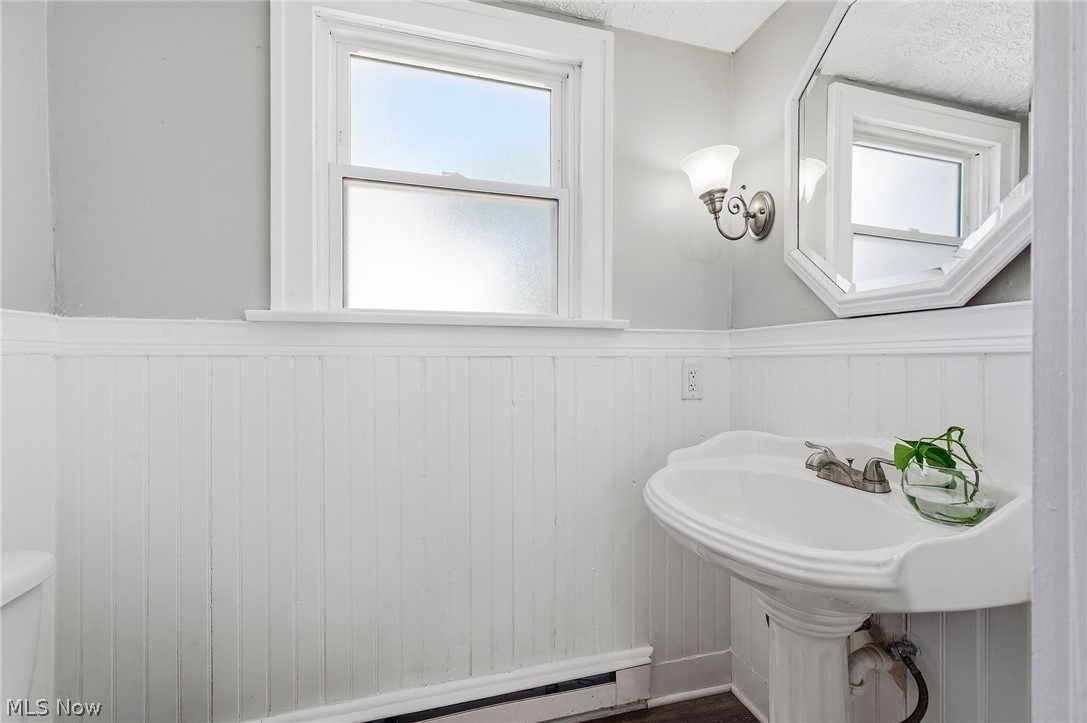 3386 Sylvanhurst Road Cleveland Heights, OH 44112 - Photo 16 of 46 Pedestal sink with dual-handle faucet, accented by a decorative wall sconce and an octagonal mirror