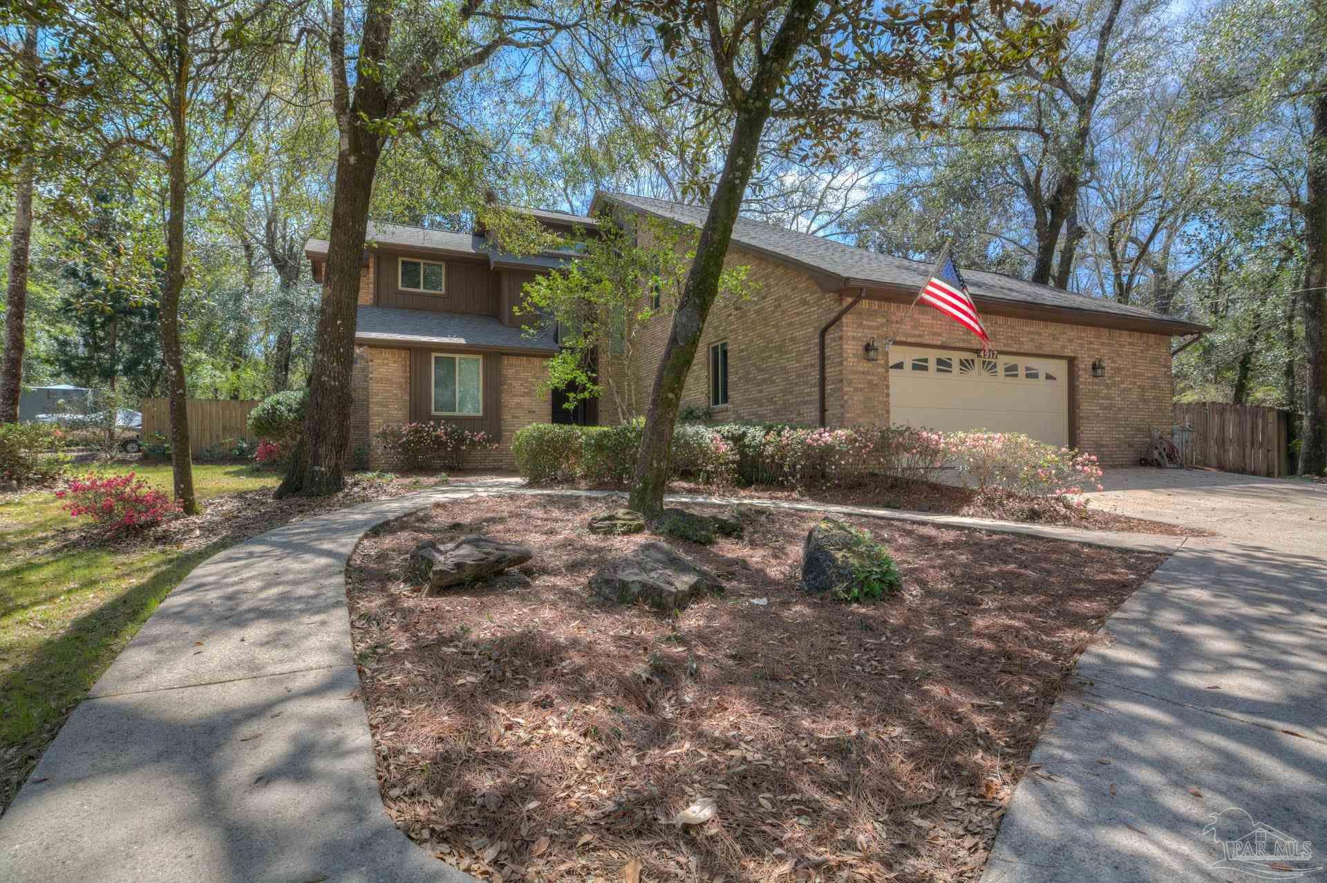 4917 Shell Road Milton, FL 32570 - Photo 1 of 49 a front view of a house with a yard and large trees
