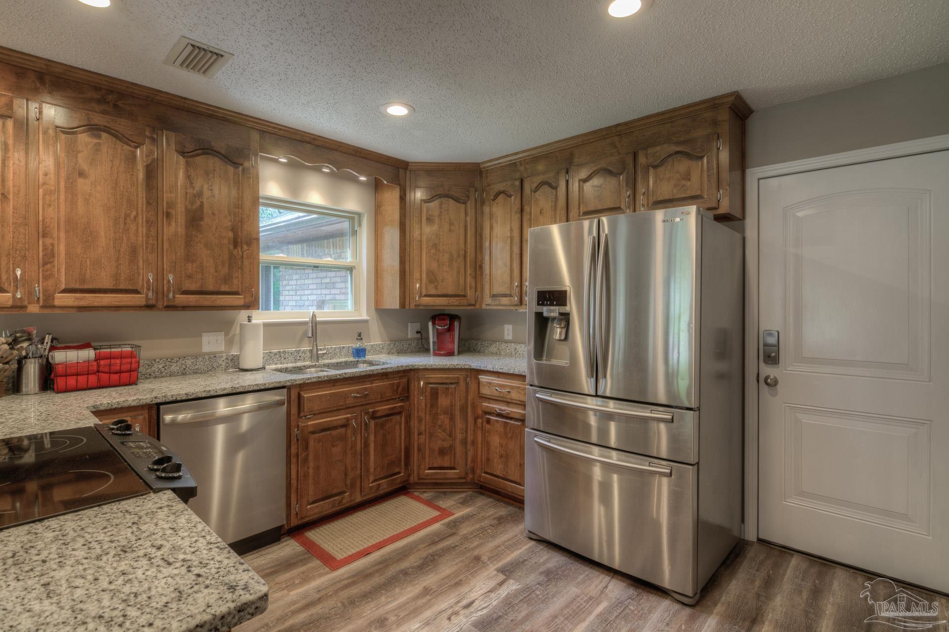 4917 Shell Road Milton, FL 32570 - Photo 13 of 49 a kitchen with stainless steel appliances granite countertop a refrigerator and a sink
