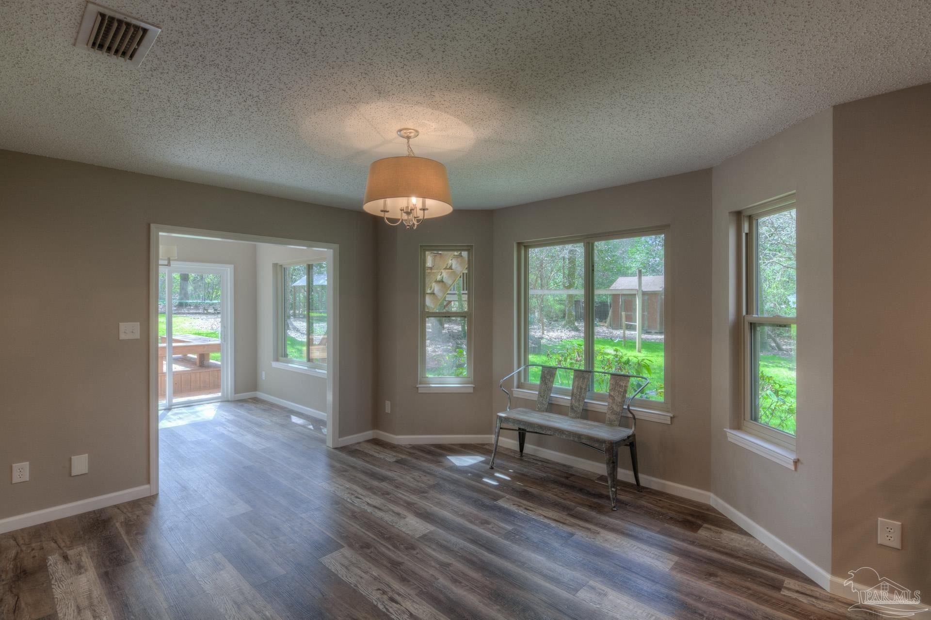 4917 Shell Road Milton, FL 32570 - Photo 17 of 49 an empty room with wooden floor and windows