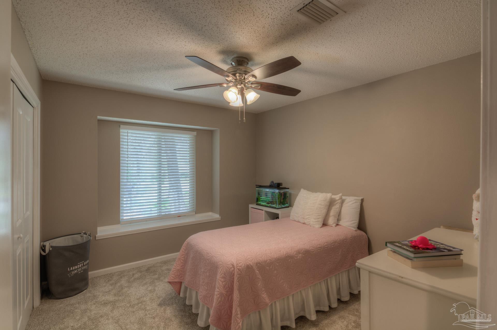 4917 Shell Road Milton, FL 32570 - Photo 18 of 49 a bedroom with a bed and a chandelier