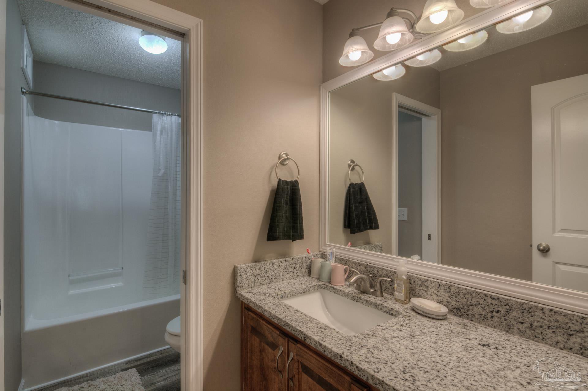 4917 Shell Road Milton, FL 32570 - Photo 19 of 49 a bathroom with a granite countertop sink and a mirror
