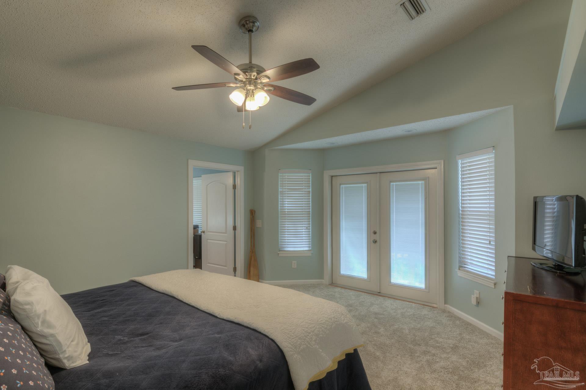 4917 Shell Road Milton, FL 32570 - Photo 25 of 49 a bedroom with a large bed and a flat tv screen on a dresser