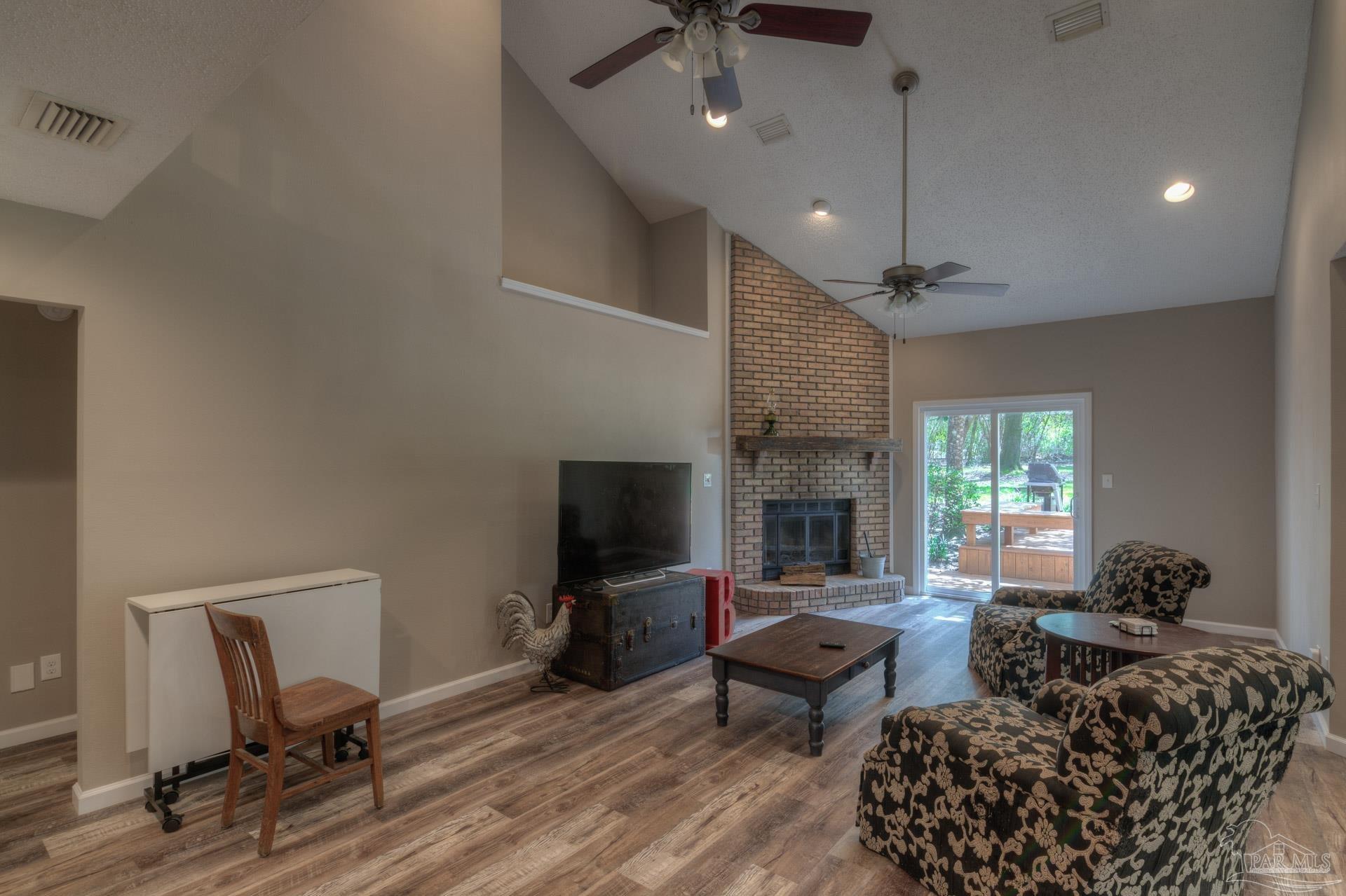 4917 Shell Road Milton, FL 32570 - Photo 8 of 49 a living room with furniture a fireplace and a flat screen tv