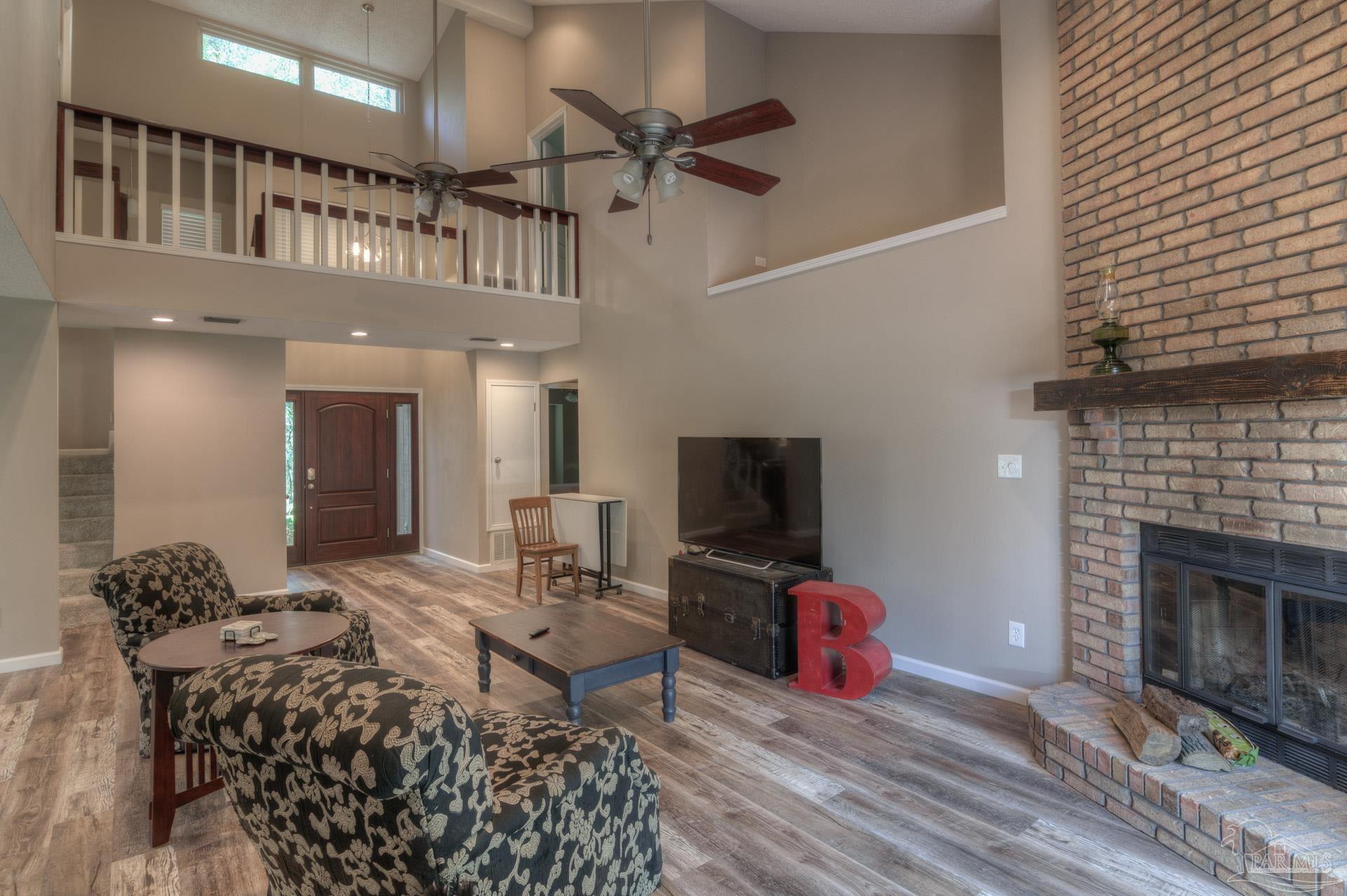 4917 Shell Road Milton, FL 32570 - Photo 10 of 49 a living room with furniture a fireplace and a flat screen tv