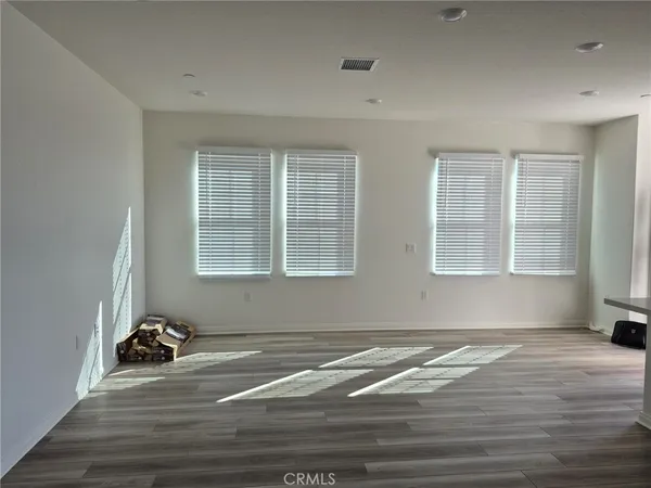 a view of a livingroom with wooden floor and a window