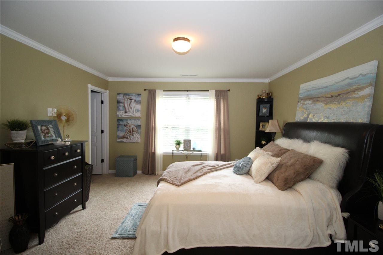 2901 Berkeley Springs Place Raleigh, NC 27616 - Photo 11 of 24 a bedroom with a bed and wooden floor
