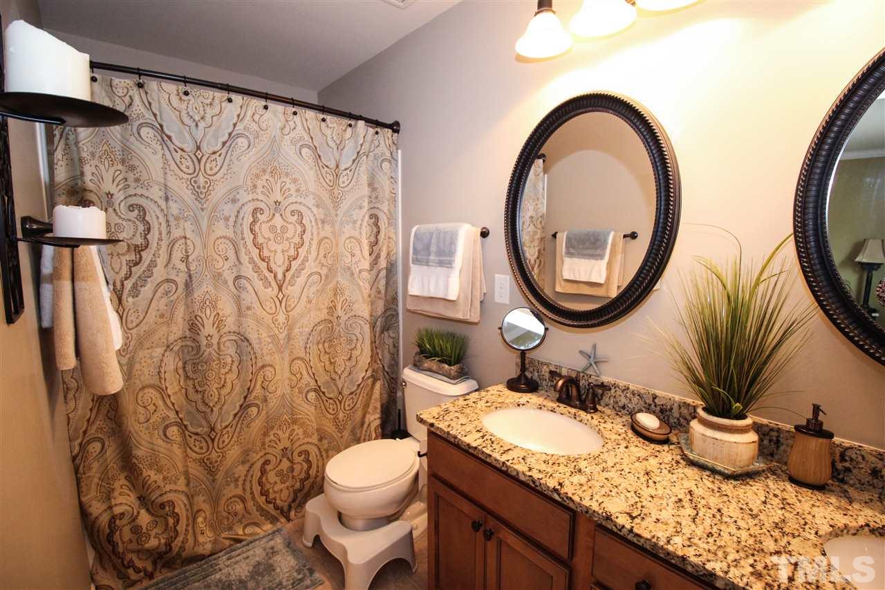 2901 Berkeley Springs Place Raleigh, NC 27616 - Photo 14 of 24 a bathroom with a granite countertop sink and a mirror