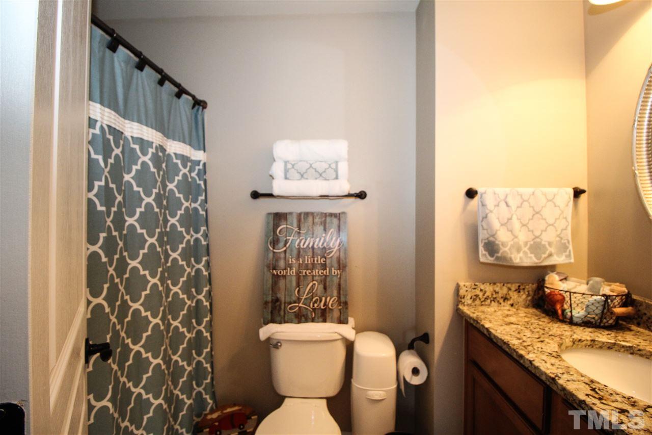 2901 Berkeley Springs Place Raleigh, NC 27616 - Photo 19 of 24 a bathroom with a granite countertop toilet sink and shower curtain