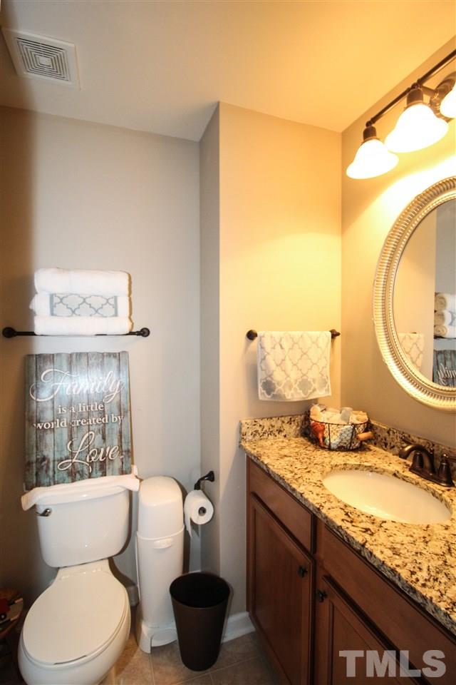 2901 Berkeley Springs Place Raleigh, NC 27616 - Photo 20 of 24 a bathroom with a granite countertop toilet sink and mirror