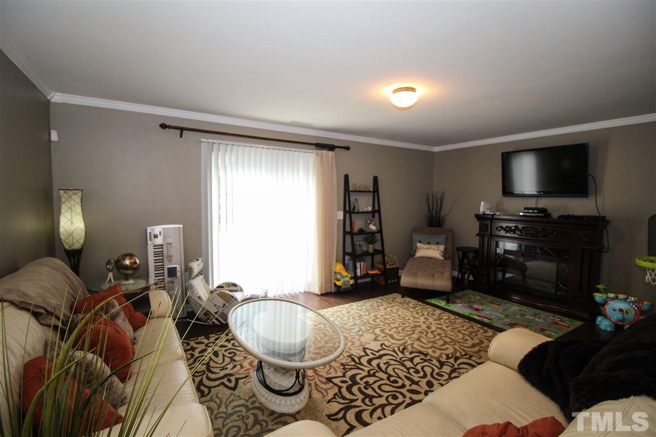 2901 Berkeley Springs Place Raleigh, NC 27616 - Photo 7 of 24 a living room with furniture a flat screen tv and a window