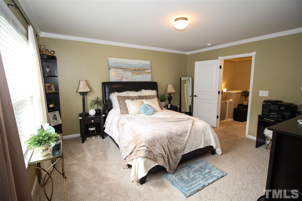 2901 Berkeley Springs Place Raleigh, NC 27616 - Photo 10 of 24 a bedroom with a bed table flowerpot and a window