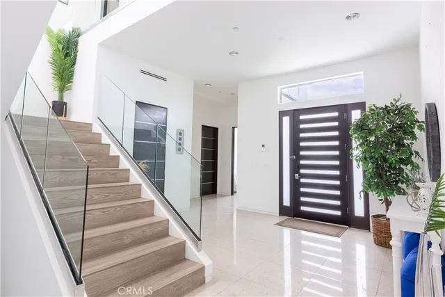 a view of staircase with lots of frames on wall and a potted plant