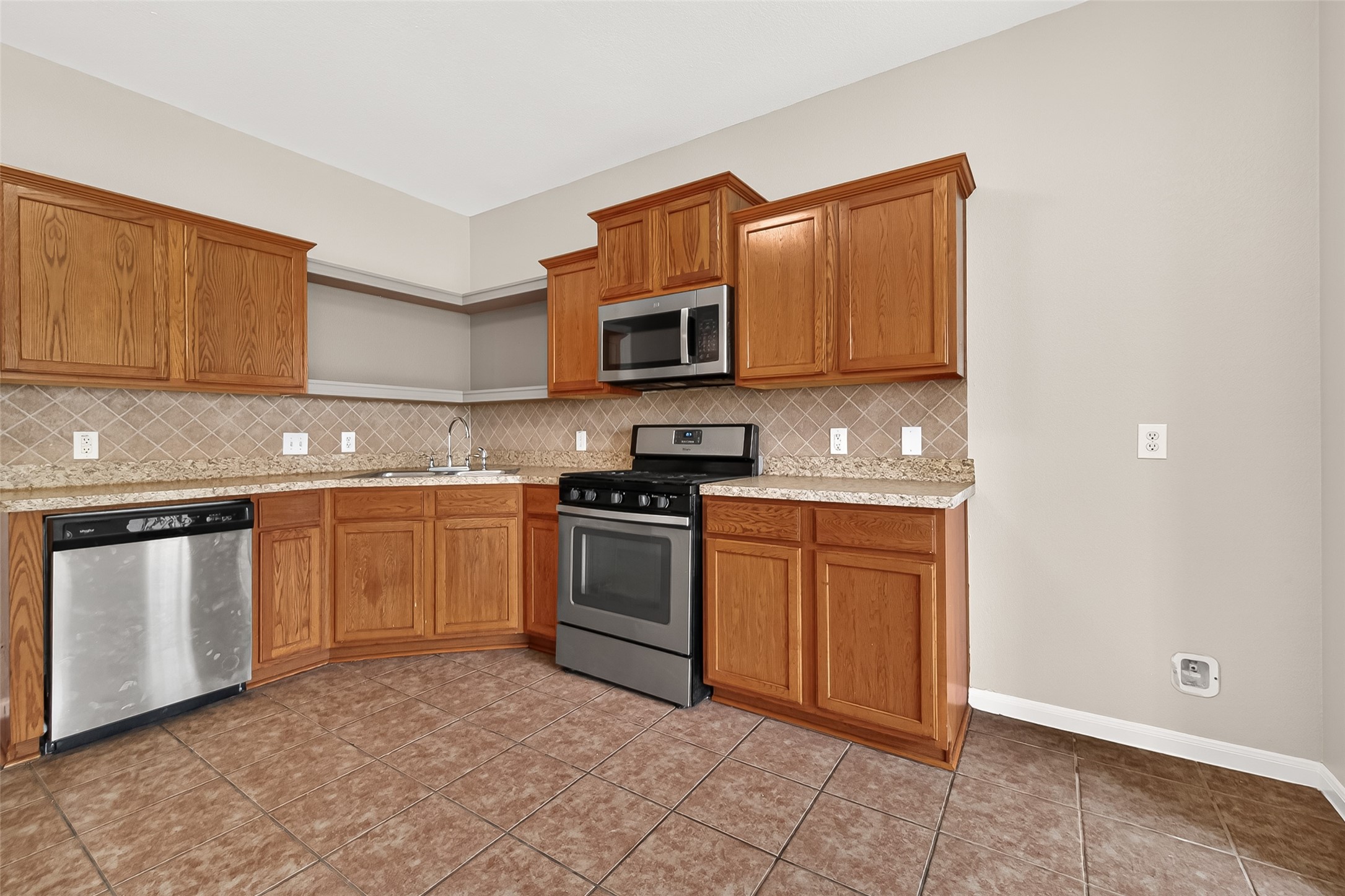 21327 Bella Flora Court Spring, TX 77379 - Photo 13 of 50 a kitchen with stainless steel appliances granite countertop a stove top oven a sink and dishwasher