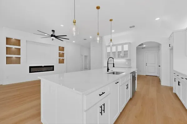 a large white kitchen with a sink a refrigerator and a stove