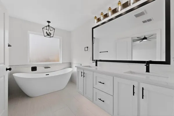 a bathroom with a bathtub sink and mirror