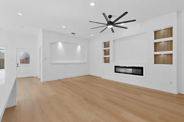 a view of a livingroom with a ceiling fan and wooden floor