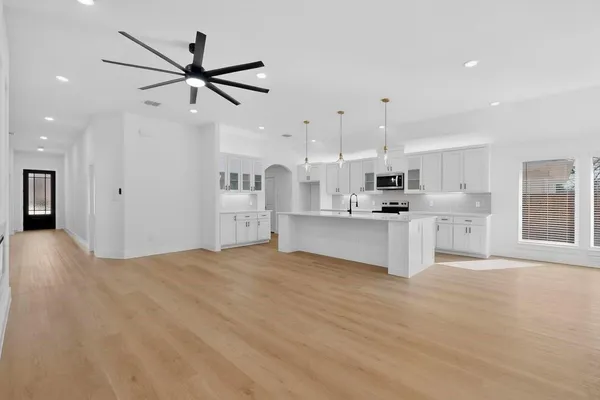 a view of a kitchen with kitchen island a sink stainless steel appliances and cabinets