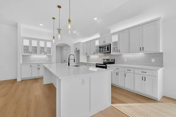 a kitchen with kitchen island a sink stainless steel appliances and cabinets