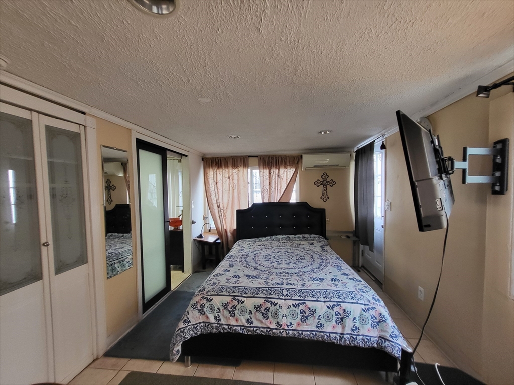 315 Main Street Everett, MA 02149 - Photo 16 of 37 a bedroom with a large bed and a dresser