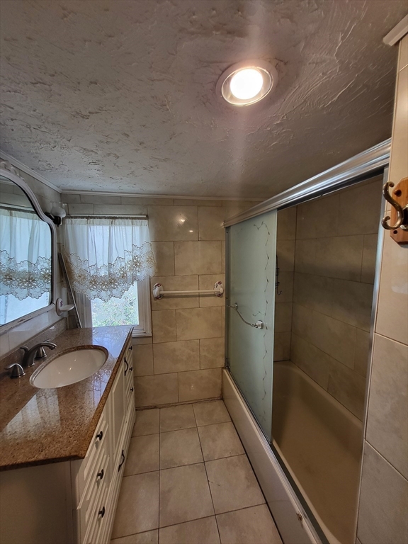 315 Main Street Everett, MA 02149 - Photo 19 of 37 a bathroom with a granite countertop sink a toilet and shower