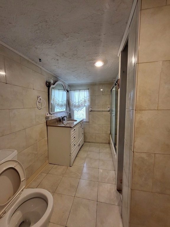 315 Main Street Everett, MA 02149 - Photo 20 of 37 a bathroom with a granite countertop sink toilet and shower