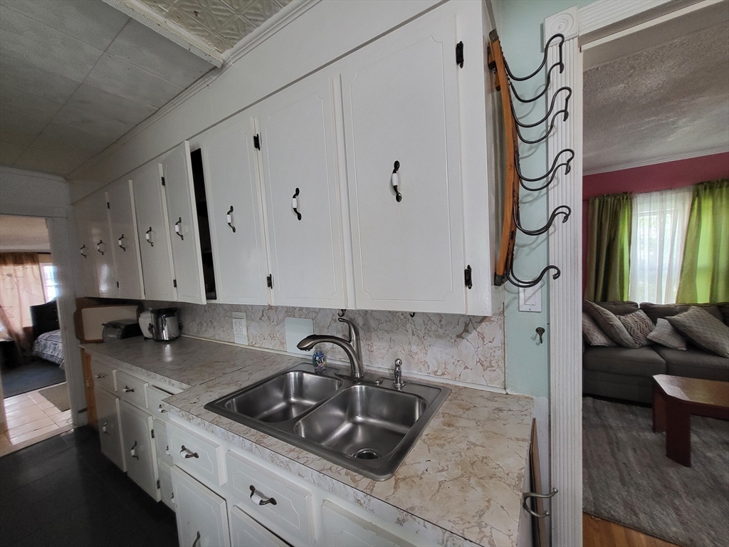 315 Main Street Everett, MA 02149 - Photo 22 of 37 a kitchen with granite countertop a sink a stove and cabinets