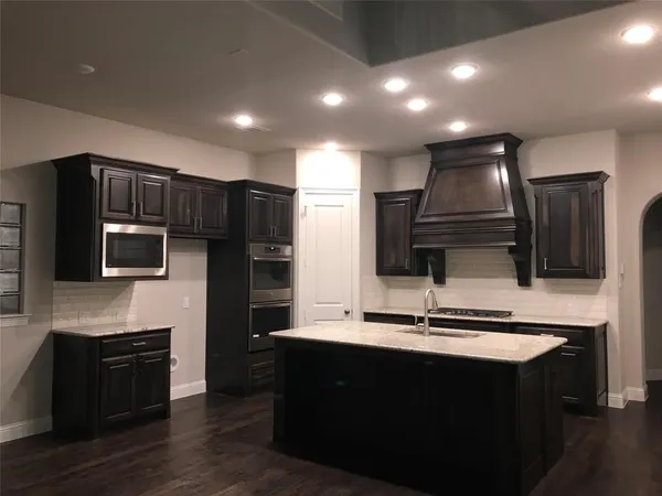 a kitchen with kitchen island stainless steel appliances a sink stove and refrigerator