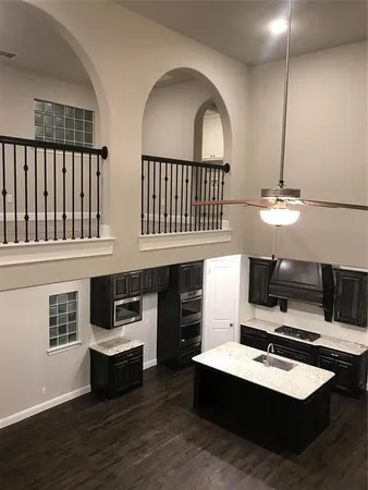 a view of a livingroom with wooden floor and kitchen view
