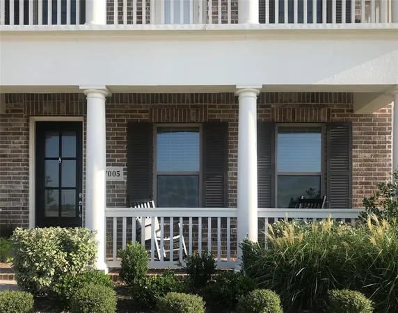 a view of a house with large windows and a small yard
