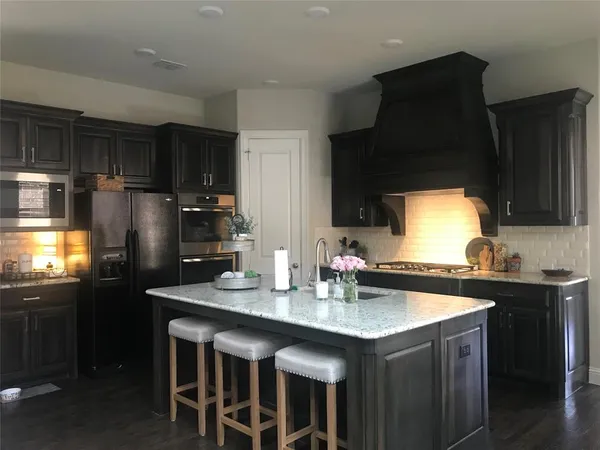 a kitchen with stainless steel appliances granite countertop a sink stove and refrigerator