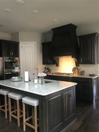 a kitchen with granite countertop a sink stove and cabinets