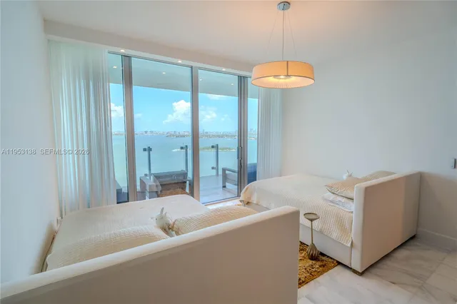 a bedroom with a large bed and a chandelier