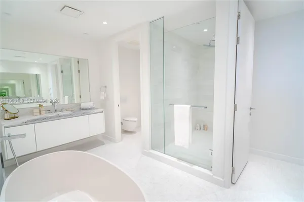 a bathroom with a white tub a sink and mirror
