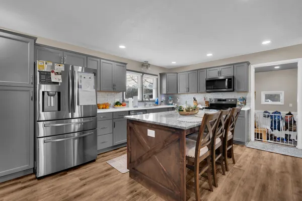 a kitchen with stainless steel appliances granite countertop a refrigerator and a sink