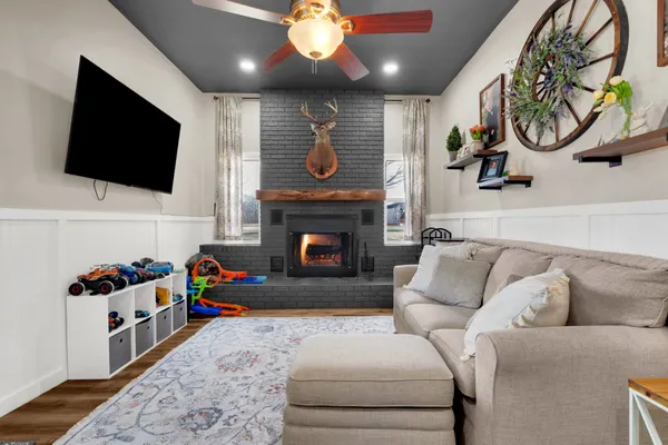 a living room with furniture a flat screen tv and a fireplace