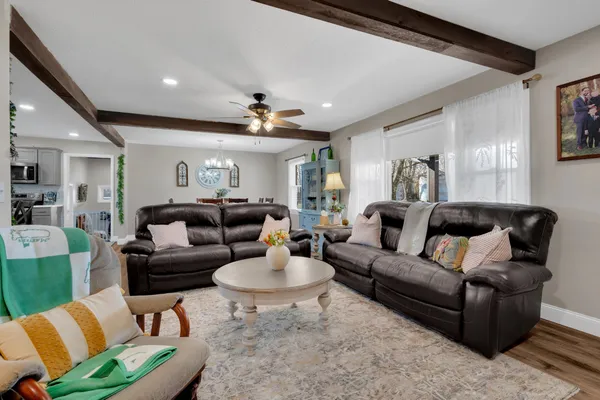 a living room with furniture a flat screen tv and a floor to ceiling window