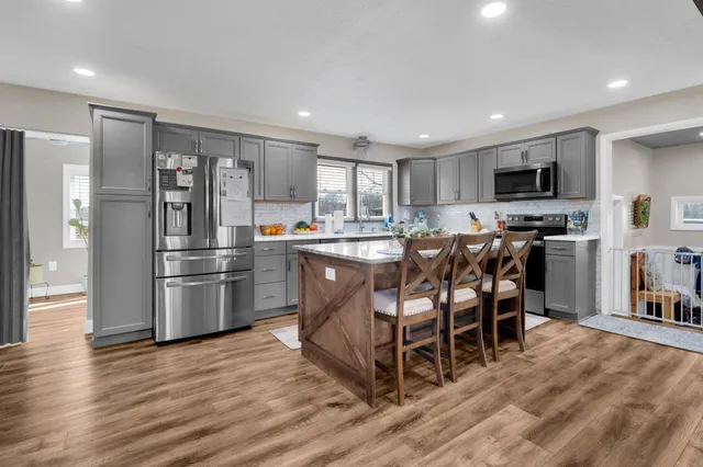 a kitchen with a table chairs refrigerator and microwave
