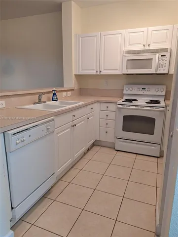 a kitchen with cabinets appliances and a sink