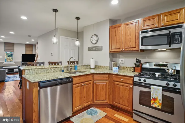 a kitchen with stainless steel appliances granite countertop a stove a sink and a microwave