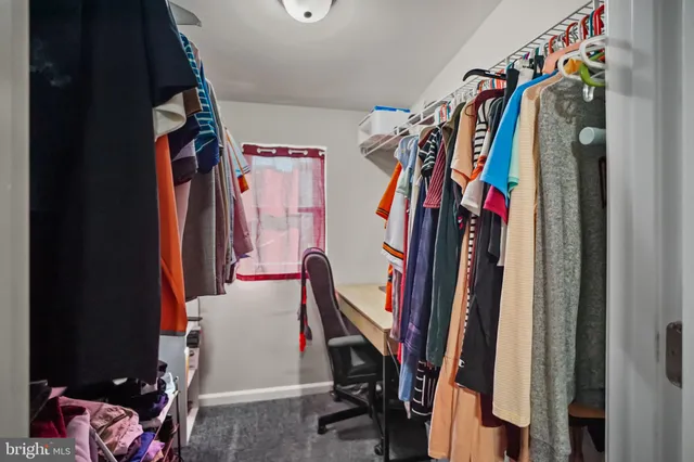 a view of walk in closet with clothes