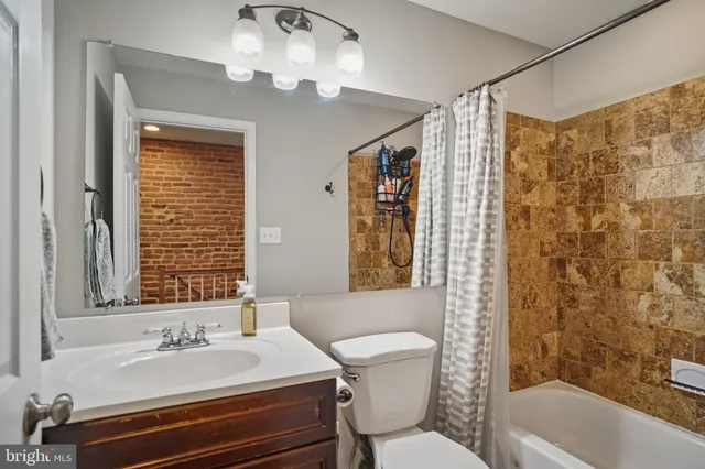 a bathroom with a sink a toilet a mirror and a tub