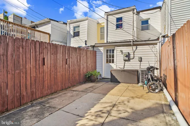 a view of a patio with a table and chairs and wooden fence