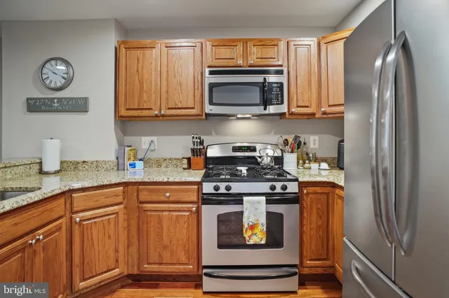 a kitchen with stainless steel appliances granite countertop a stove and a refrigerator
