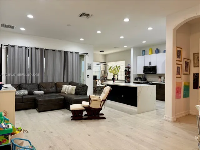 a living room with furniture and kitchen view